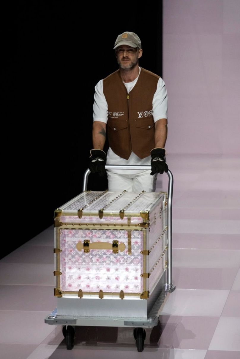 A man presents a suitcase as part of the men's Louis Vuitton Fall-Winter 2025-2026 collection