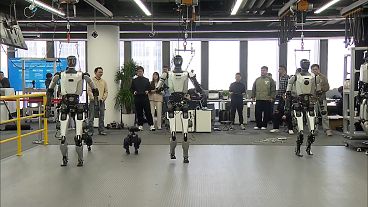 Four humanoid robots walking at the National and Local Co-Built Humanoid Robotics Innovation Center