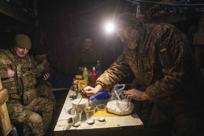 Um militar ucraniano da 26.ª brigada de artilharia faz café depois de disparar contra posições russas na linha da frente na região de Donetsk, quarta-feira, 22/01/2025.