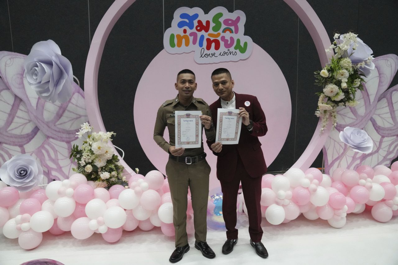 Pisit Sirihirunchai, left, and Chanatip Sirihirunchai from the LGBTQ+ community show their marriage certificates after the Marriage Equality Act