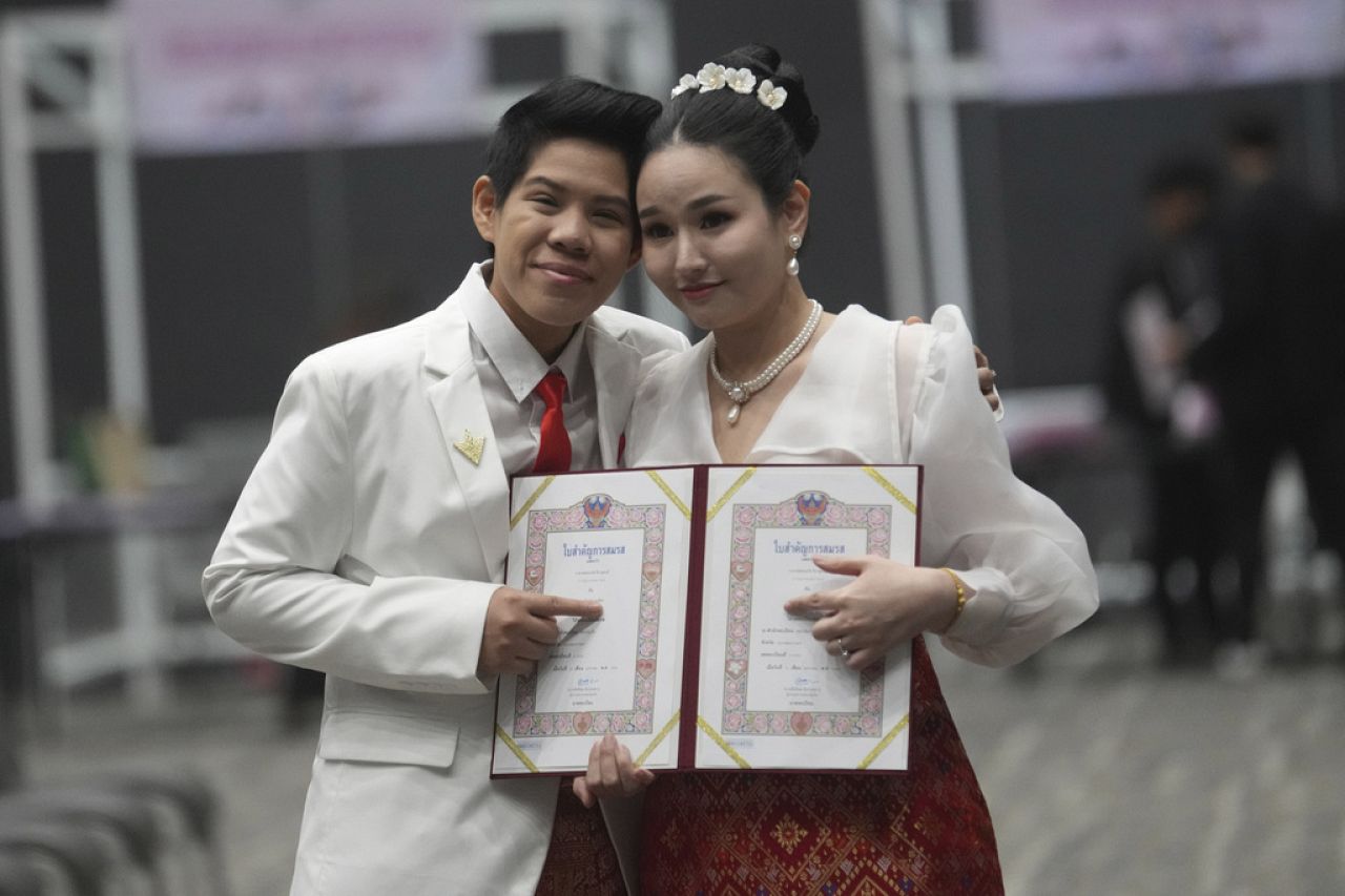 Kwanporn Kongpetch, left, and Ploynaplus Chirasukon from the LGBTQ+ community show their marriage certificates after the Marriage Equality Act.