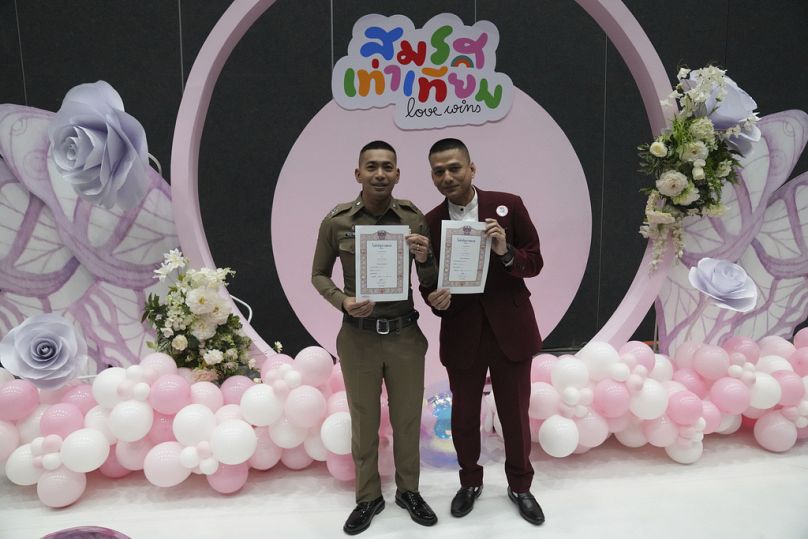 Pisit Sirihirunchai, à esquerda, e Chanatip Sirihirunchai, da comunidade LGBTQ+, mostram as suas certidões de casamento após a Lei da Igualdade no Casamento.