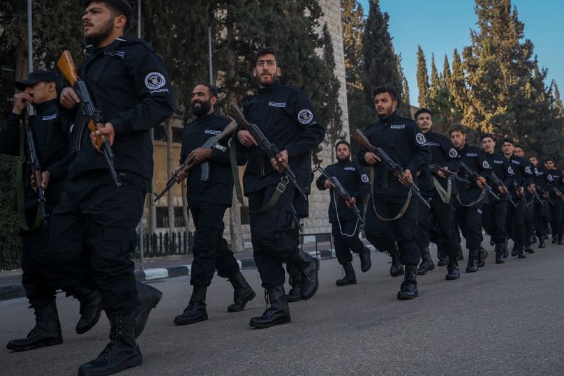 مجندون في قوات الشرطة التابعة للحكومة السورية الانتقالية يحملون السلاح خلال دورة تدريبية وتخرج في كلية الشرطة في دمشق، سوريا، الثلاثاء 14 يناير/كانون الثاني 2025