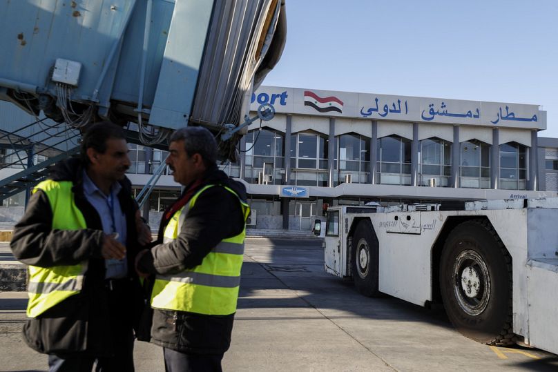 موظفون يقفون على مدرج مطار دمشق الدولي أثناء إعادة فتح المطار للرحلات الداخلية في دمشق سوريا 18 كانون الأول ديسمبر 2024