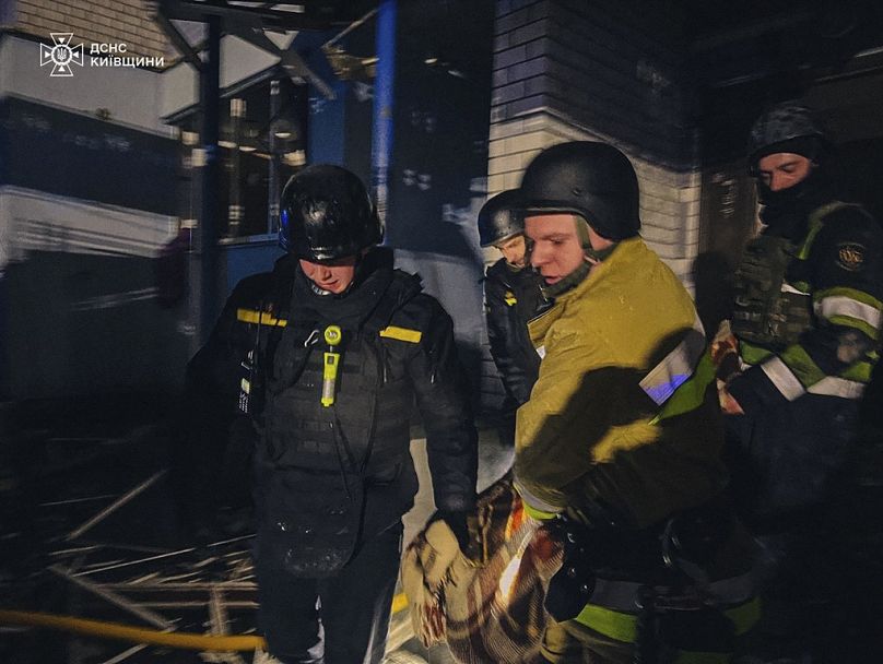 El personal de los servicios de emergencia transporta el cuerpo de un residente local después de un ataque con un dron ruso en la región de Kiev, Ucrania, 24 de enero de 2025