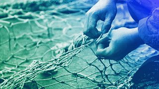 DOSSIER : Un membre de l'équipage du navire de pêche Sophie Louise II répare les filets déchirés sur le quai, à North Shields, dans le nord-est de l'Angleterre, en décembre 2007.