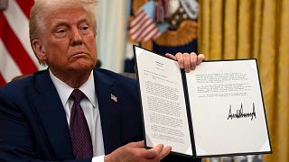 President Donald Trump holding up a order for clemency for anti-abortion protesters as he signs executive orders in the Oval Office of the White House, Thursday, Jan. 23, 2025