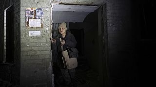 An elderly woman leaves her damaged home after missile attack in Zaporizhzhia, Ukraine, Thursday, Jan. 23, 2025. 