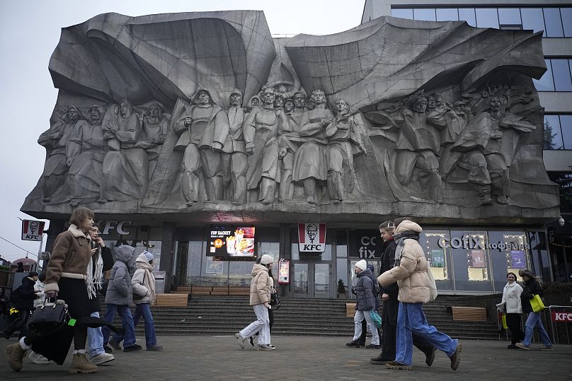 Pessoas caminham junto a um baixo-relevo de solidariedade em Minsk, 25 de janeiro de 2025