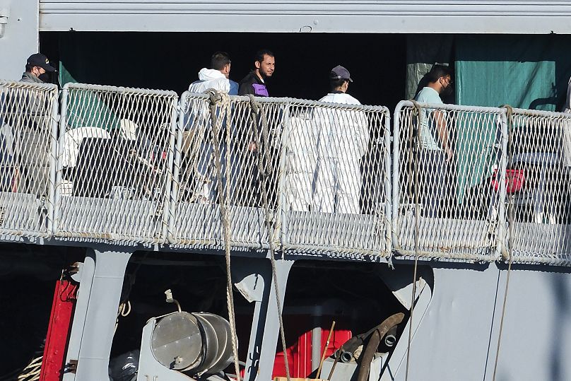 مهاجرون ينزلون من السفينة ليبرا التابعة للبحرية الإيطالية في ميناء شنغين، شمال غرب ألبانيا، الجمعة، 8 نوفمبر/تشرين الثاني 2024