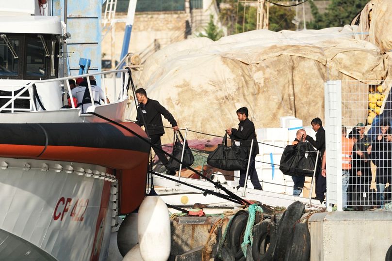 المهاجرون على متن سفينة تابعة لخفر السواحل الإيطالي في ميناء شنغن في ألبانيا  بعد أن رفضت محكمة في روما احتجازهم، السبت 19 أكتوبر/تشرين الأول 2024