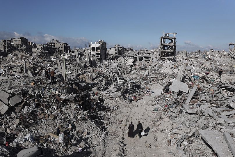 Palestinos caminan entre la destrucción causada por la ofensiva aérea y terrestre israelí en Jabaliya, 20 de enero de 2025.