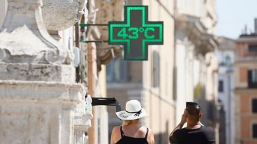 A man takes a photo of the temperature of 43C recorded in the sun outside a pharmacy in downtown Rome. A man takes a photo of the temperature of 43C recorded in the sun outside a pharmacy in downtown Rome.