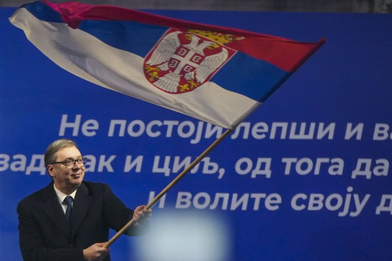 Il presidente serbo Aleksandar Vucic sventola una bandiera serba dopo un comizio nella città Jagodina, Serbia, 24 gennaio 2025