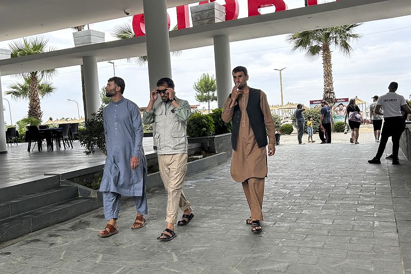 پناهجویان افغان درحال قدم زدن در شهر شنگجین واقع در ۷۰ کیلومتری غرب تیرانا