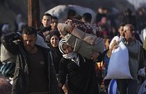 A Palestinian woman carries her belongings home in the north of the Gaza Strip, 28.01.2025