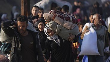 A Palestinian woman carries her belongings home in the north of the Gaza Strip, 28.01.2025