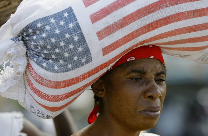 FILE: A woman carries a bag containing rice donated by USAID as she walks through a market in Leogane, Haiti, Jan. 16, 2010.