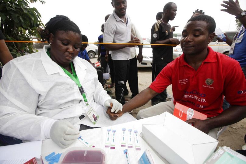 FILE: A doctor takes an AIDS/HIV blood test from citizens in Lagos, Nigeria, Saturday, Dec. 1, 2012