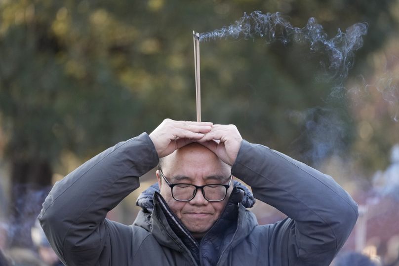 Ein Mann mit Räucherstäbchen betet am ersten Tag des chinesischen Mondneujahrs im Lama-Tempel in Peking am Mittwoch, 29. Januar 2025. 