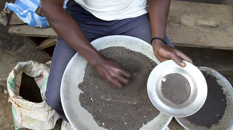 A Congolese miner sifts through ground rocks to separate out the cassiterite, the main ore that's processed into tin, in the town of Nyabibwe, eastern Congo, Aug. 16, 2012.