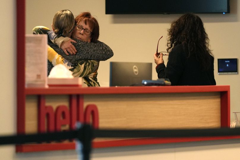 Des femmes s'embrassent dans la salle de réception du Skating Club of Boston, où six athlètes, entraîneurs et membres de la famille associés au club auraient péri dans la coll