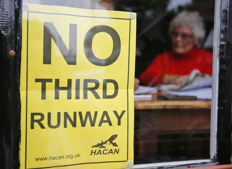 A sign reads 'No Third Runway' in the window of a pub in Hammondsworth, London where residents would be affected