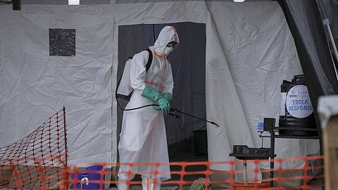 A medical worker disinfects a tent used for suspected Ebola victims inside the isolation center of Madudu Health Center III, Tuesday, Nov. 1, 2022.