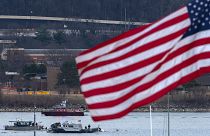 A diving team and police boat are seen around a wreckage site in the Potomac River from Ronald Reagan Washington National Airport, 30 January, 2025
