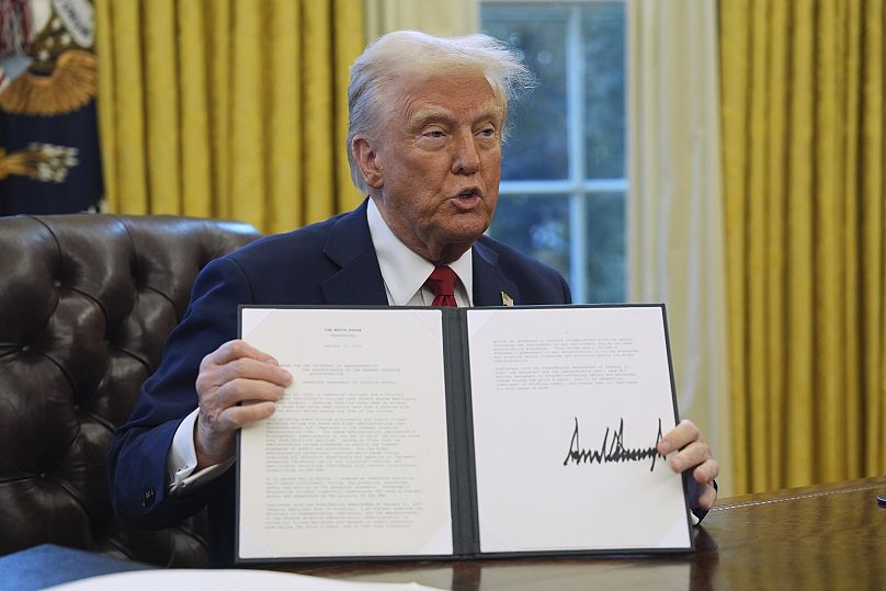 President Donald Trump holds a document regarding aviation security in the Oval Office at the White House, 30 January, 2025