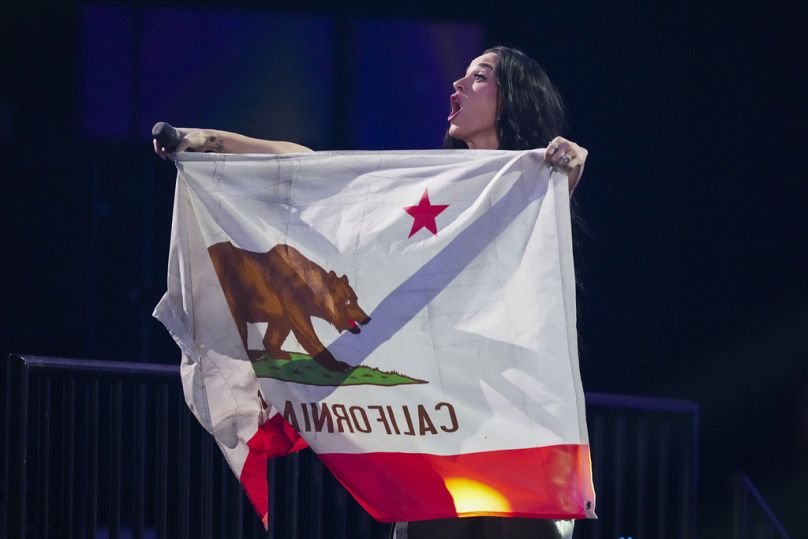  Katy Perry se produit lors du concert de bienfaisance FireAid, tenant le drapeau de la Californie.