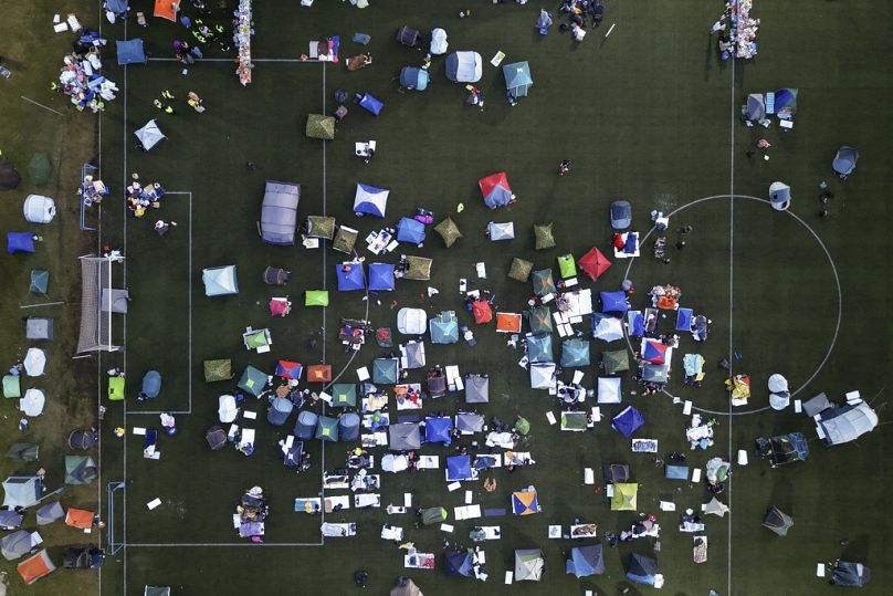 Widok z lotu ptaka na studentów śpiących w namiotach na stadionie piłkarskim, którzy biorą udział w marszu i proteście przeciwko zawaleniu się betonowego zadaszenia