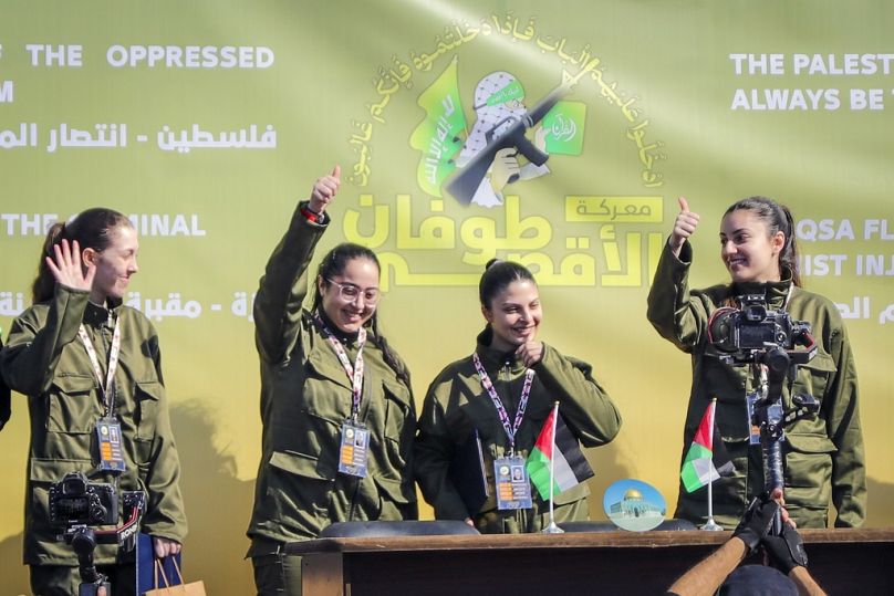 Les femmes israéliennes otages Naama Levy, Daniella Gilboa, Karina Ariev et Liri Albag, dans le désordre, saluent la foule palestinienne avant d'être remises à la Croix-Rouge 
