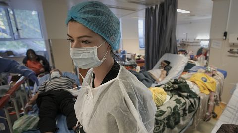 A member of the medical staff walks in a crowded COVID-19 isolation room at the University Emergency Hospital in Bucharest, 22 October, 2021