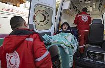 A Palestinian girl wounded in the Israeli bombardment of the Gaza Strip is carried by medics before crossing the Rafah border into Egypt, as wounded and sick Palestinians are 