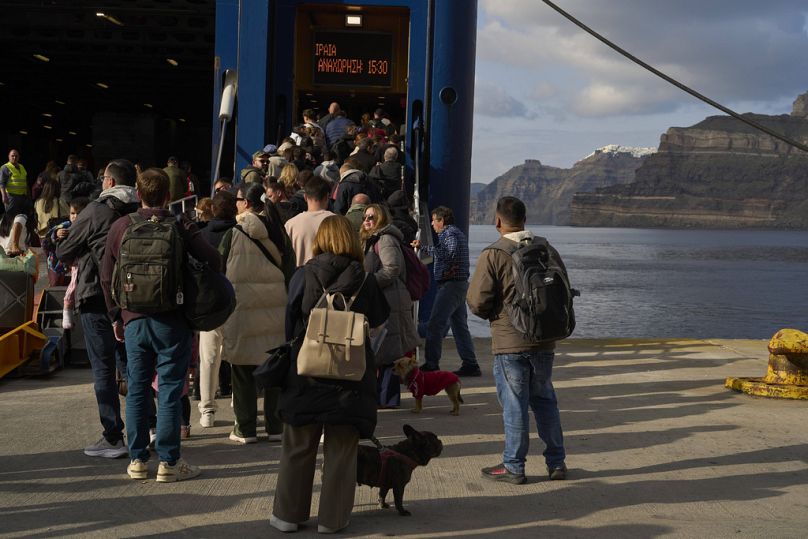 Des passagers embarquent à bord d'un ferry régulier à destination de la ville d'Athènes. 