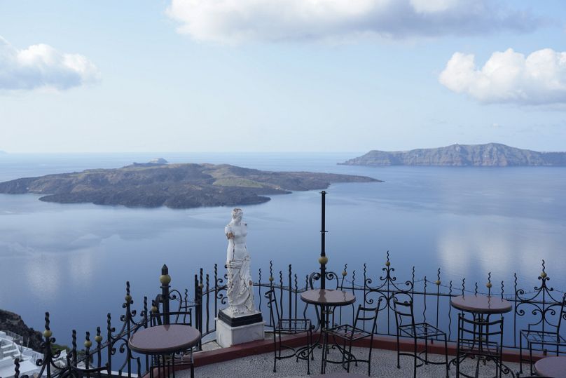 The volcanic island of Nea Kameni, left, is seen from Fira town as Greek authorities are taking emergency measures in response to seismic activity on Santorini, February 2025 