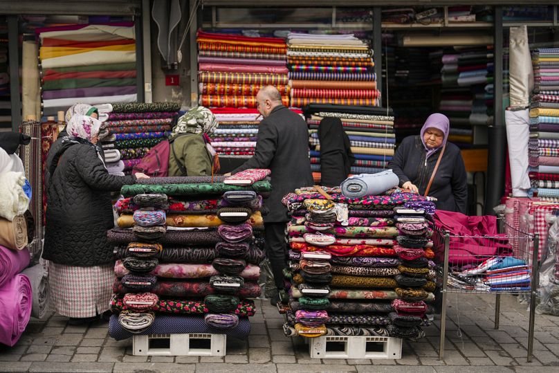 امرأة تنظر إلى قطع من القماش في سوق بمنطقة أمينونو التجارية في إسطنبول بتركيا 23 كانون الثاني يناير 2025