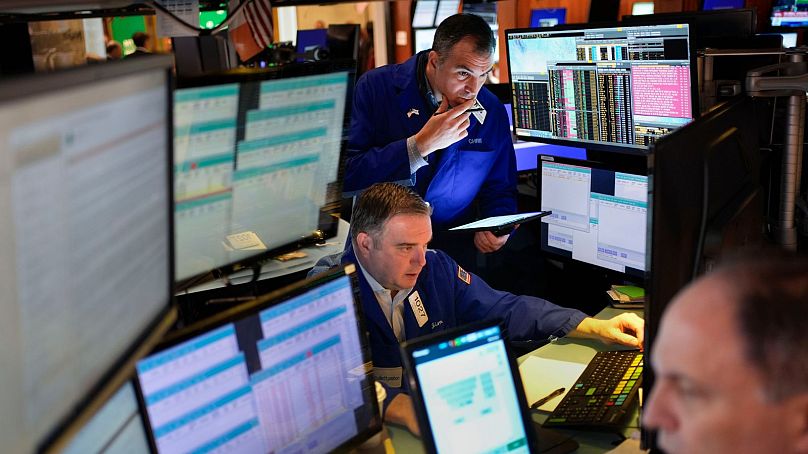 Traders work on the floor at the New York Stock Exchange in New York.