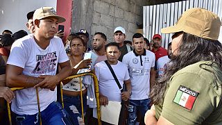 A Mexican migration officer explains to migrants that permission to travel across Mexico to the US-Mexico border was suspended.