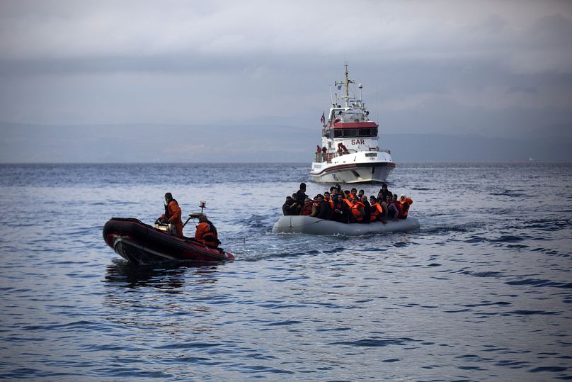 Des agents de Frontex tirent un canot pneumatique avec des migrants vers le village de Skala Sikaminias sur l'île grecque de Lesbos, le mercredi 21 octobre 2015.