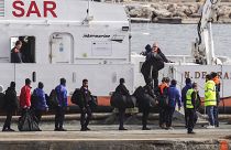 Migrants board an Italian Coast Guard vessel as part of a transfer operation from the asylum processing centers in Albania back to Italy following a court decision in Rome, at