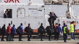 Migrants board an Italian Coast Guard vessel as part of a transfer operation from the asylum processing centers in Albania back to Italy following a court decision in Rome, at