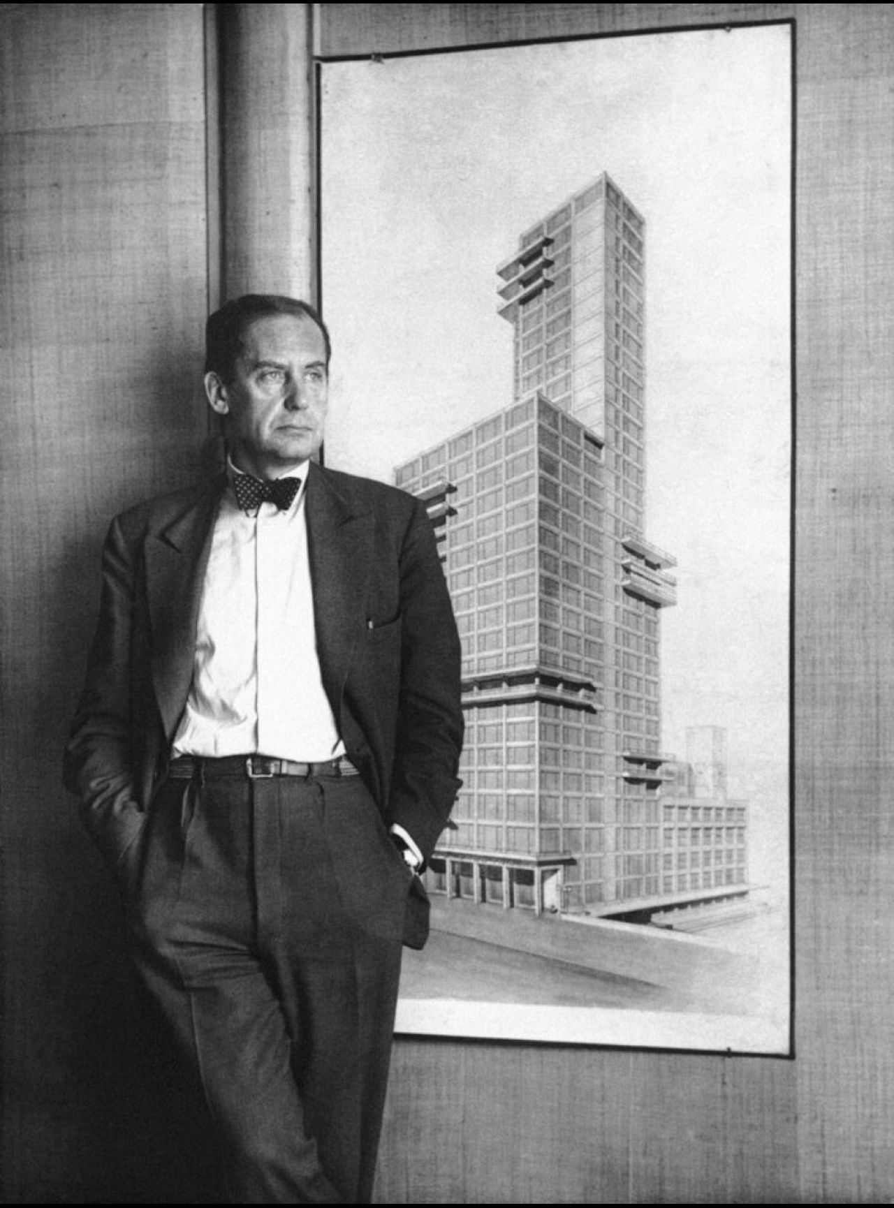 German architect professor Walter Gropius from Berlin is shown standing in front of a drawing of one of his projects, a design for the Chicago Tribune building. Date unknown.