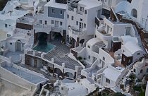 An empty swimming pool is seen in a group of clifftop buildings in the town of Oia on the earthquake-struck island of Santorini, Greece.