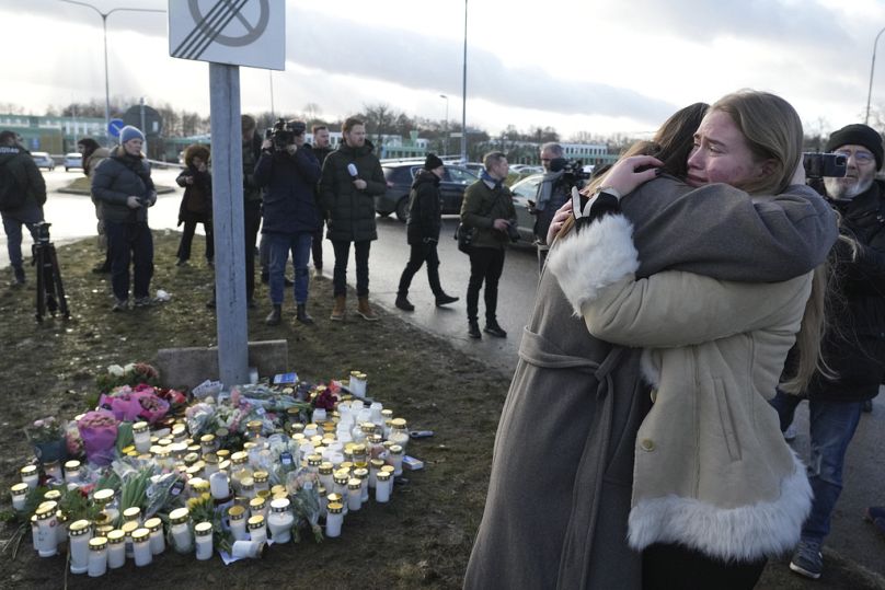 People gather at a makeshift memorial near the scene of a shooting on the outskirts of Orebro, Sweden, Wednesday, Feb. 5, 2025. 