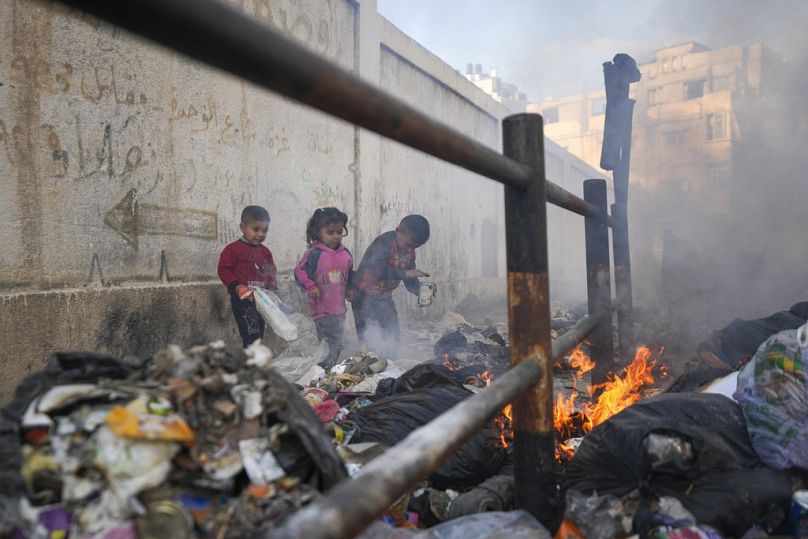 أولاد يلهون قرب كومة نفايات مشتعلة، في غزة، 4 شباط 2025.       