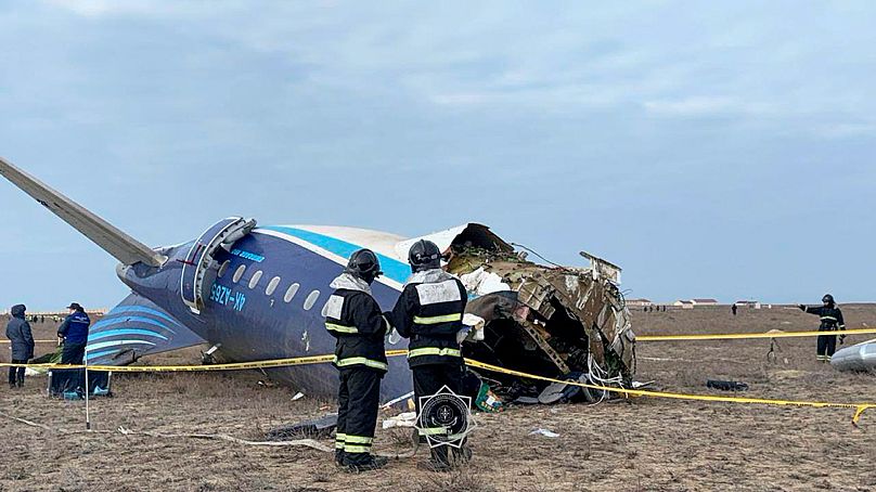 Rescuers work at the wreckage of Azerbaijan Airlines Embraer 190 lays on the ground near the airport of Aktau, 25 December, 2024