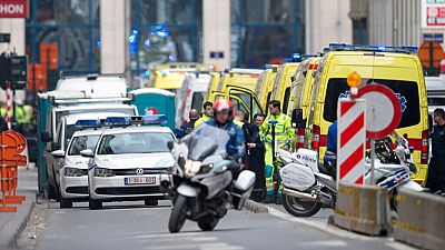 A police motorcycle rides by ambulances at a staging station near a metro after an explosion in Brussels on Tuesday, March 22, 2016.