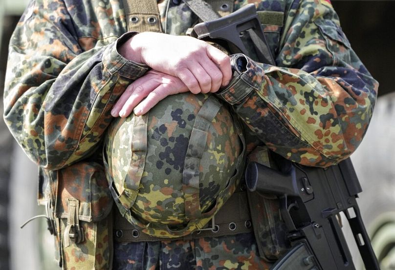 Ein deutscher Soldat hält seinen Helm während eines Besuchs von Gouverneur Hendrick Wuest in der Feldmarschall-Rommel-Kaserne in Augustdorf, Deutschland, 30. März 2022